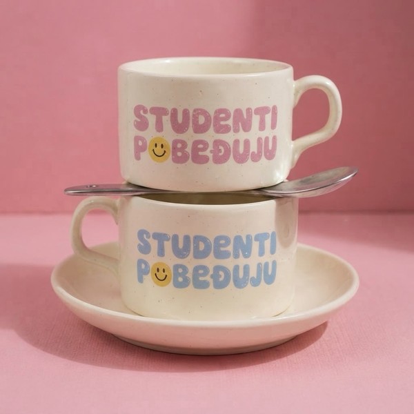 Dve bele šolje sa tacnom, natpis Studenti pobeđuju u roze i plavoj boji